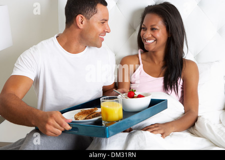 Homme Femme apportant le petit déjeuner au lit sur le bac Banque D'Images