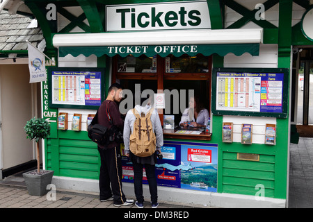 Les touristes achetant des billets pour une croisière sur le lac Windermere à une billetterie à Bowness-on-Windermere, Lake District, Cumbria, Angleterre, Royaume-Uni Banque D'Images