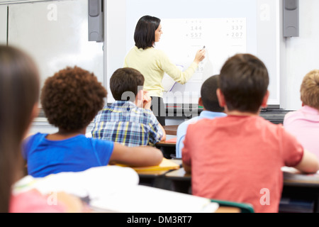 Teacher Standing In classe à l'aide du tableau blanc interactif Banque D'Images