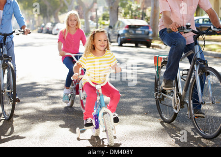 Rue de banlieue sur famille à vélo Banque D'Images