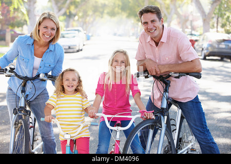 Rue de banlieue sur famille à vélo Banque D'Images