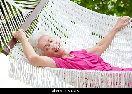 Senior Woman Relaxing In Hammock Beach Banque D'Images