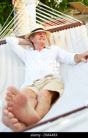 Senior Woman Relaxing In Hammock Beach Banque D'Images