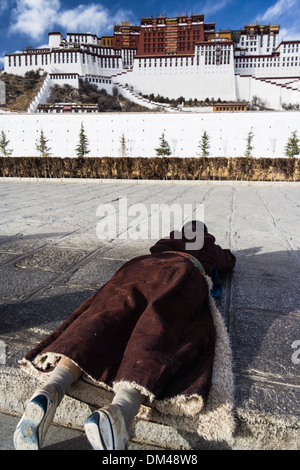 Pèlerin se prosterna faisant la kora du palais du Potala. Lhassa, Tibet Banque D'Images