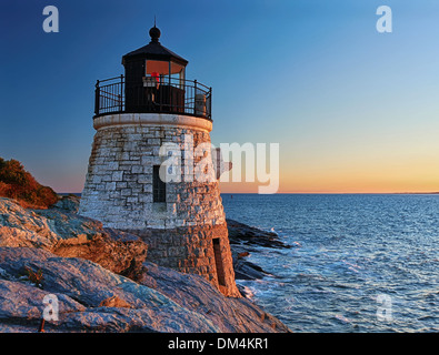 Beau vieux phare sur les roches au coucher du soleil Banque D'Images