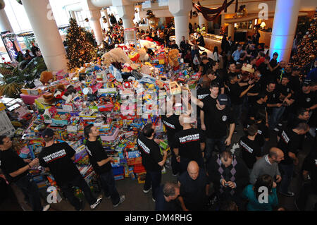 Vancouver, Canada. Dec 11, 2013. Pompiers de Vancouver s'empiler jouets offerts par les résidents au cours de la 26e assemblée annuelle de Noël Petit-déjeuner souhaite Pan Pacific à Vancouver, Canada, le 11 décembre 2013. L'année dernière, l'hôtel Pan Pacific a vu plus de 5 000 visiteurs venant de faire don de plus de 12 tonnes de jouets et de 25 000 $ en espèces pour aider les enfants nécessiteux durant la saison de Noël. Crédit : Sergei Bachlakov/Xinhua/Alamy Live News Banque D'Images