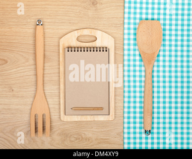 Des ustensiles de cuisine avec notepad pour copier l'espace sur la table en bois Banque D'Images