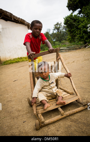 Enfants jouant avec une poussette (PRAM) dans le district de Vatomandry, Madagascar. Banque D'Images