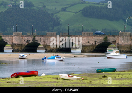 Des bateaux de pêche à marée basse et de la Maza Bridge à San Vicente de la Barquera, Cantabrie, Espagne. Banque D'Images