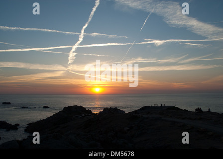 Coucher du soleil par Corbiere Lighthouse sur côte ouest de Jersey à marée haute avec la chaussée sous l'eau. Banque D'Images