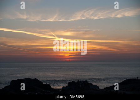 Coucher du soleil par Corbiere Lighthouse sur côte ouest de Jersey à marée haute avec la chaussée sous l'eau. Banque D'Images