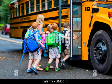 Un groupe de jeunes enfants s'inscrire à l'schoolbus Banque D'Images