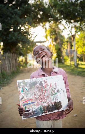 Enfant montrant leur œuvre dans le district de Vatomandry, Madagascar. Banque D'Images