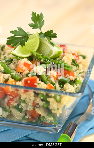 Le quinoa végétarien plat d'asperges vertes et poivron rouge, garni de tranches de lime et de feuilles de persil Banque D'Images