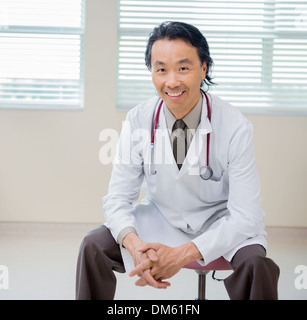 Portrait Of Happy Doctor Sitting in Hospital Room Banque D'Images