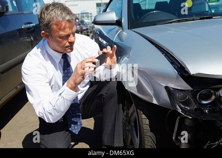 Loss Adjuster Inspecting Car impliqué dans un accident Banque D'Images