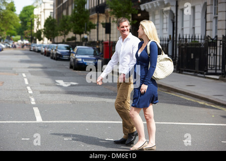Couple avec femme enceinte Crossing City Road Banque D'Images