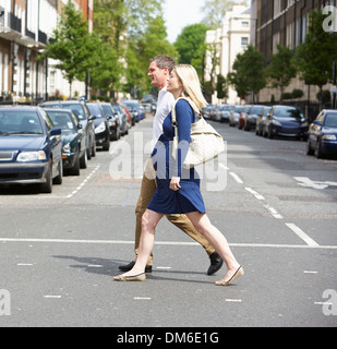 Couple avec femme enceinte Crossing City Road Banque D'Images