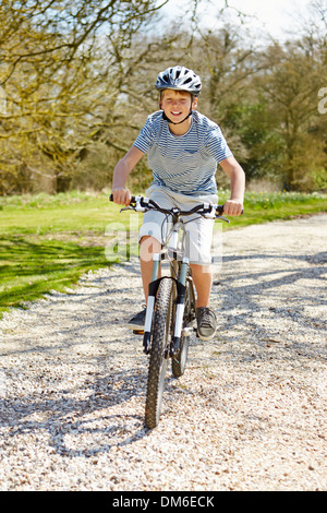 Young Boy Riding Bike le long de la voie de Pays Banque D'Images