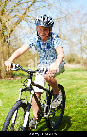 Young Boy Riding Bike le long de la voie de Pays Banque D'Images