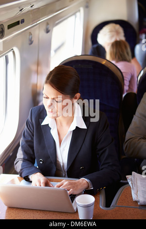 Businesswoman pour se rendre à son travail sur le Train and Using Laptop Banque D'Images