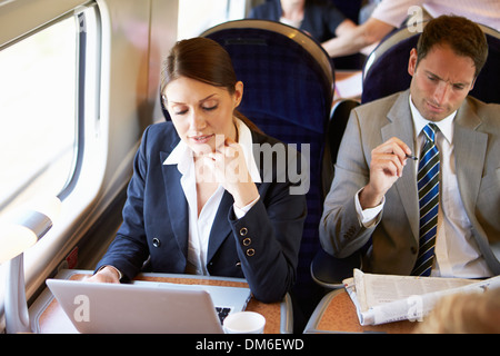 Businesswoman pour se rendre à son travail sur le Train and Using Laptop Banque D'Images