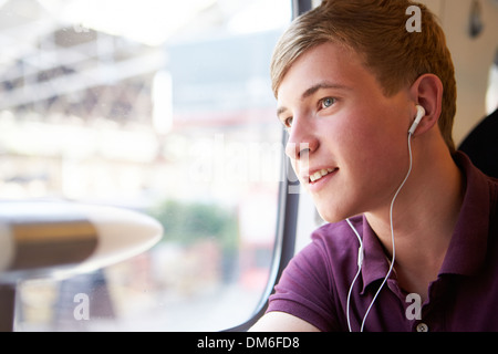 Jeune homme écoute de la musique sur Voyage en Train Banque D'Images