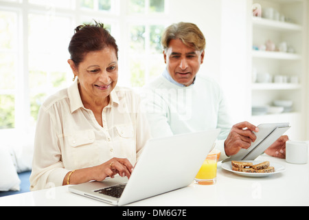 Couple Indien Senior Using Laptop and Digital Tablet Banque D'Images