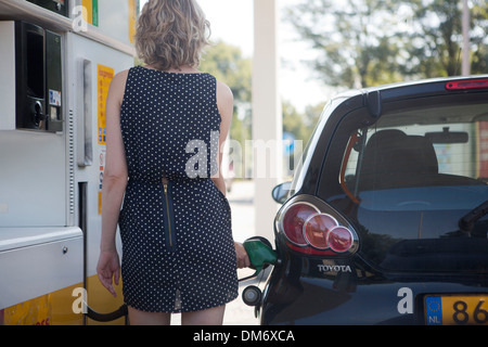 Femme se remplit sa voiture avec du carburant Banque D'Images