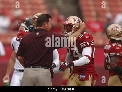 Atlanta Falcon entraîneur en chef Jim Mora Jr. embrasse 49er Mike Rumph évoluait avant le début de l'après-midi dimanche match entre les San Francisco 49ers et les Falcons d'Atlanta au Candlestick Park de San Francisco, Californie le 12 septembre 2004. Mora a été le coordonnateur de la défensive des 49ers depuis plusieurs années. Sacramento Bee photographie par Jose Luis Villegas, 12 Septembre 2004/ZUMA Pr Banque D'Images