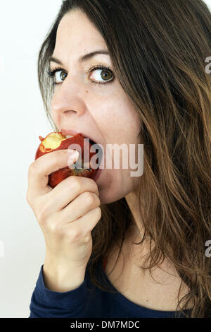 Berlin, Allemagne. 09Th Nov, 2013. Une jeune femme mange une pomme rouge à Berlin, Allemagne, 02 décembre 2013. Photo : Jens Kalaene - MODÈLE LIBÉRÉ/dpa/Alamy Live News Banque D'Images