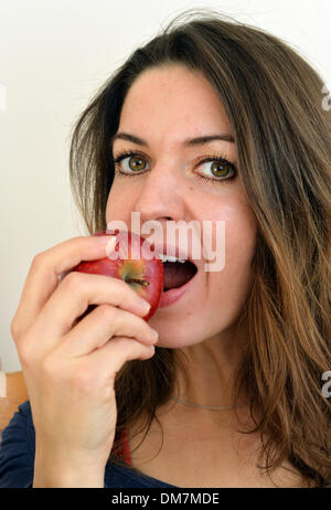 Berlin, Allemagne. 09Th Nov, 2013. Une jeune femme mange une pomme rouge à Berlin, Allemagne, 02 décembre 2013. Photo : Jens Kalaene - MODÈLE LIBÉRÉ/dpa/Alamy Live News Banque D'Images