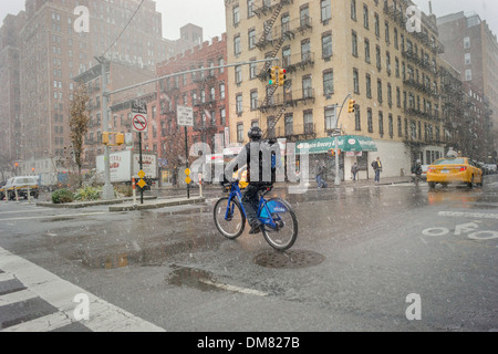 Un cycliste sur un CitiBike ligne pures traverse par dans le quartier de Chelsea, New York Banque D'Images