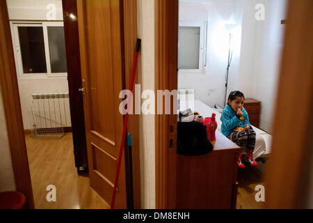 Madrid, Espagne. Dec 11, 2013. Nicole Marin, 4 ans mange des mandarines tôt le matin dans sa chambre alors qu'elle attend de sa mère la chercher à l'école pendant l'expulsion de John à Madrid, Espagne, mercredi, le 11 décembre 2013. John Nanez Betancur est devenu chômeur après avoir perdu son emploi. Il a acheté un euro 213,000 ($ 291,360) vacances en prenant un prêt hypothécaire auprès de la banque Bankia en 2005 mais a cessé de payer en raison de sa situation financière en 2010. Il a vécu dans l'appartement avec Jose Arcila âgé de 50 ans, sa femme Betsi Ojeda, 33 ans, sans emploi, et la fille de Betsi, Nicole Marin, 4 ans. L Banque D'Images