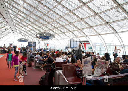 Les voyageurs dans une salle d'attente à l'aéroport Charles de Gaulle, Paris, France. Banque D'Images