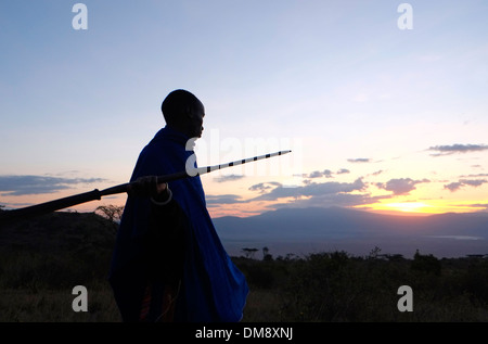 La silhouette du guerrier Massaï tenant une lance dans les plaines de la zone de conservation de Ngorongoro cratère dans la région des hautes terres de Tanzanie Afrique de l'Est Banque D'Images