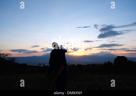 Guerrier massaï jetant une lance dans la zone de conservation de Ngorongoro cratère dans la région des hautes terres de Tanzanie Afrique de l'Est Banque D'Images