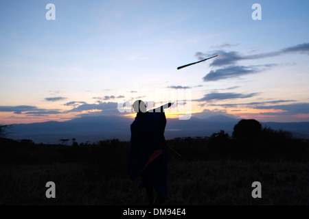 Guerrier massaï jetant une lance dans la zone de conservation de Ngorongoro cratère dans la région des hautes terres de Tanzanie Afrique de l'Est Banque D'Images