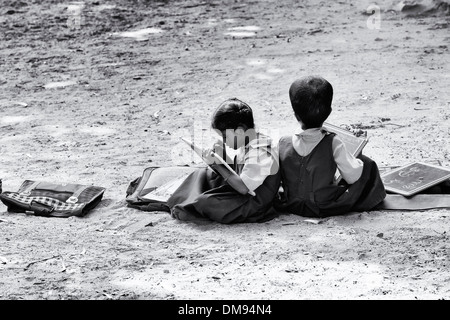 Les enfants de l'école village situé dans une classe en dehors de l'écriture sur un tableau noir comprimés. L'Andhra Pradesh, Inde. Monochrome Banque D'Images