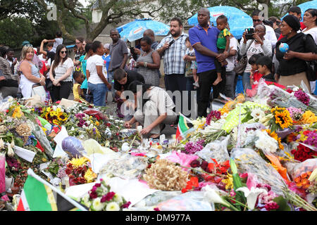 Johannesburg, Afrique du Sud. Dec 12, 2013. Personnes se rassemblent pour déposer des fleurs et rendre hommage à l'extérieur de la maison de Nelson Mandela à Houghton Johannesburg. L'Afrique du Sud Jeudi 12 Décembre 2013 Photo par Zute Lightfoot/Alamy Live News Banque D'Images