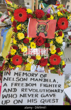 Des fleurs et des messages ont été laissés à la statue de Nelson Mandela à la place du Parlement, Londres, après sa mort survenue le 5 décembre 2013 Banque D'Images