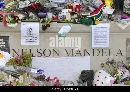 Des fleurs et des messages ont été laissés à la statue de Nelson Mandela à la place du Parlement, Londres après sa mort survenue le 5 décembre 2013 Banque D'Images