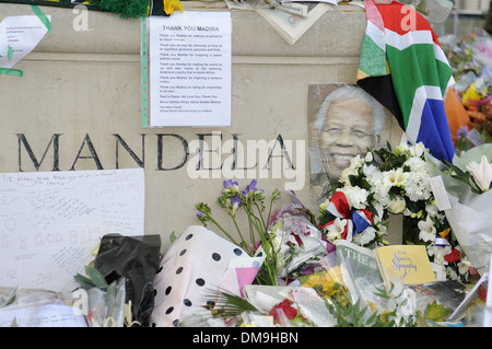 Fleur et messages ont été laissés à la statue de Nelson Mandela à la place du Parlement, Londres après sa mort survenue le 5 décembre 2013 Banque D'Images