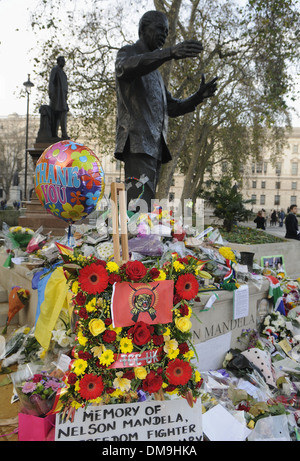 Fleur et messages ont été laissés à la statue de Nelson Mandela à la place du Parlement, Londres après sa mort survenue le 5 décembre 2013. Banque D'Images