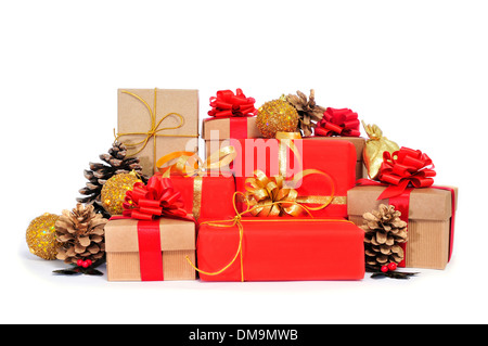 Certains cadeaux de Noël enveloppée avec du papier d'emballage de différentes couleurs et de petits nœuds, et quelques boules de Noël sur fond blanc ba Banque D'Images