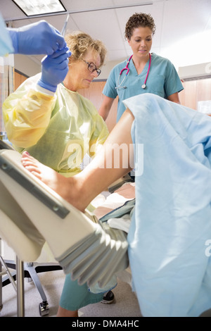 Réception chirurgien ciseaux du collègue bébé tout en offrant Banque D'Images