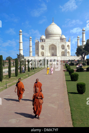 Taj Mahal en soirée. Les moines bouddhistes en premier plan. dames en saris à moyenne distance. Banque D'Images