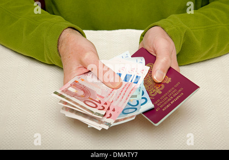 Gros plan des mains d'homme tenant des billets d'euros européens Argent billets de banque en espèces et passeport britannique England UK United Royaume GB Grande-Bretagne Banque D'Images