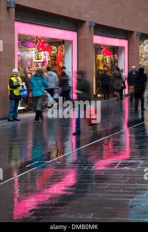 Liverpool, Merseyside, Royaume-Uni. 13 Décembre, 2013. Une chaussée mouillée réflexions et de charité des capteurs solaires de Santa Jumper jour à l'appui de Macmillan 'Porter votre Noël Jour de cavalier'. La campagne a été en association avec des jus de FM et a aidé à recueillir des fonds essentiels pour les personnes vivant avec le cancer dans la région de Merseyside. Le centre-ville a organisé un "porter un cavalier Noël' événement pour lancer une campagne d'un mois pour créer le plus grand album photo en ligne de gens portant des cavaliers de Noël. © Mar Photographics/Alamy vivre Banque D'Images