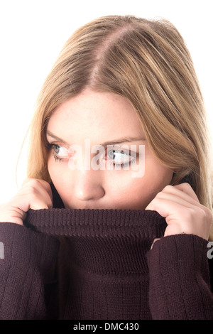 Jeune femme sentant le froid tirant sur un tricot brun épais chandail de laine ou de pontage pour garder au chaud Banque D'Images